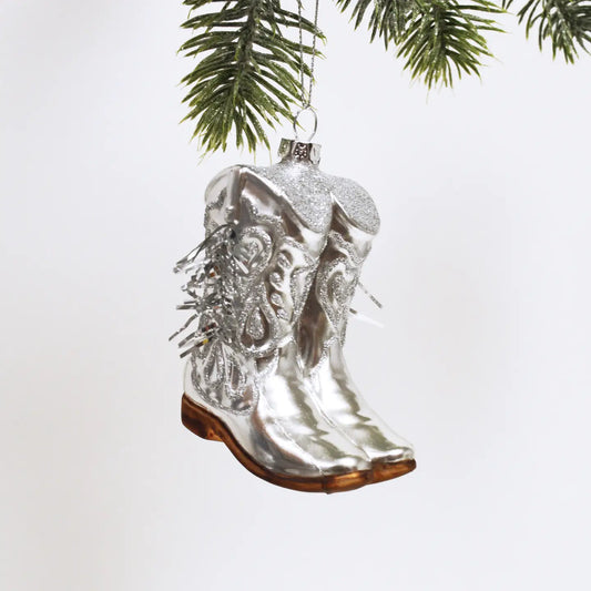 Boot stompin' into the holidays with our Cowboy Boot Ornament! 🌟👢

Perfect for western enthusiasts, this elegant ornament features exquisite glass craftsmanship and stunning hand-painted silver details with tinsel fringe, adding a disco party vibe to your décor 🤠🪩

Each ornament comes beautifully boxed, making it a thoughtful holiday gift. Ready to hang, it can be cherished for years to come! Elevate your holiday aesthetics with this unique piece.